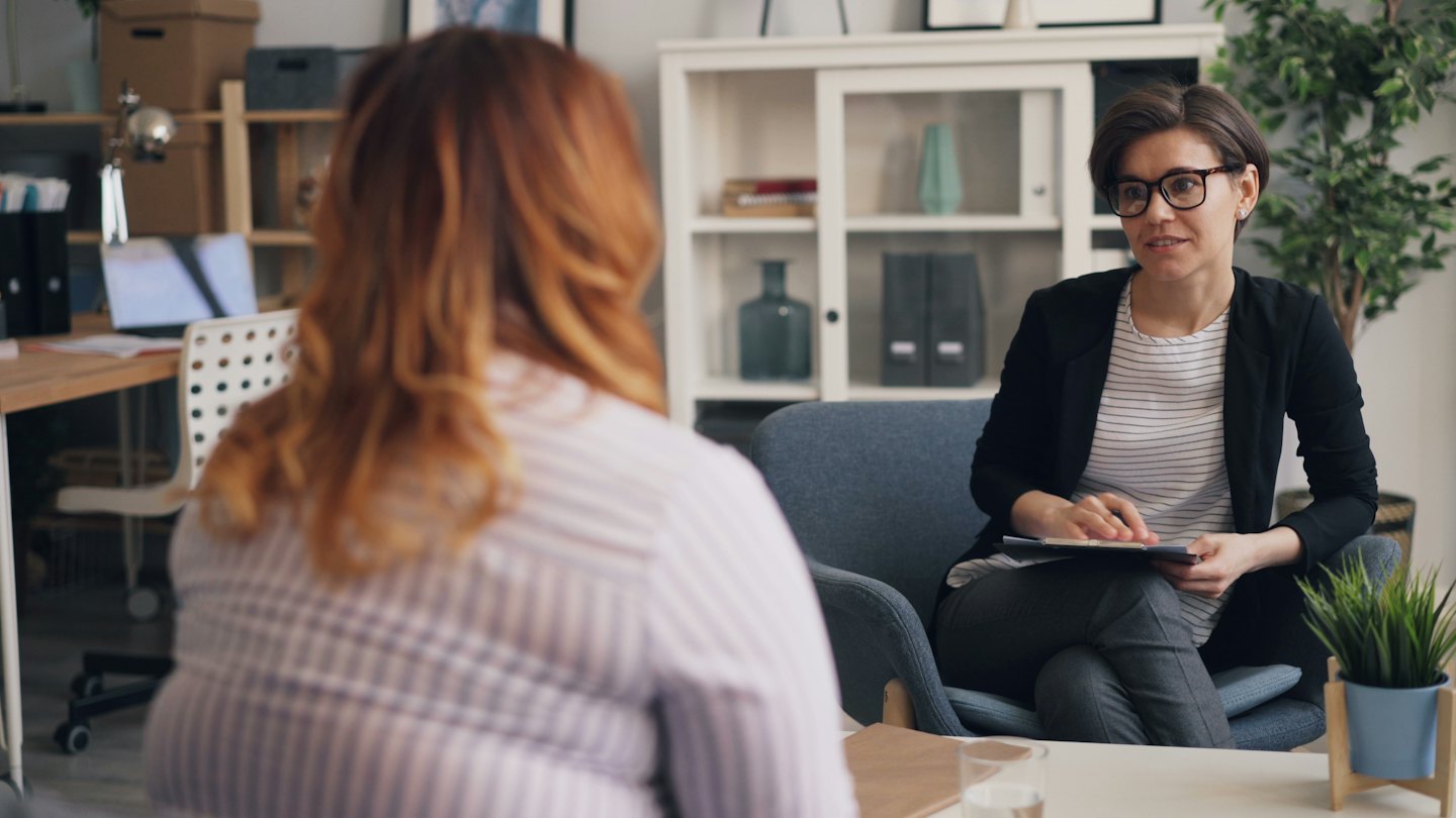 Deux femmes en séance de consultation professionnelle dans un bureau lumineux.