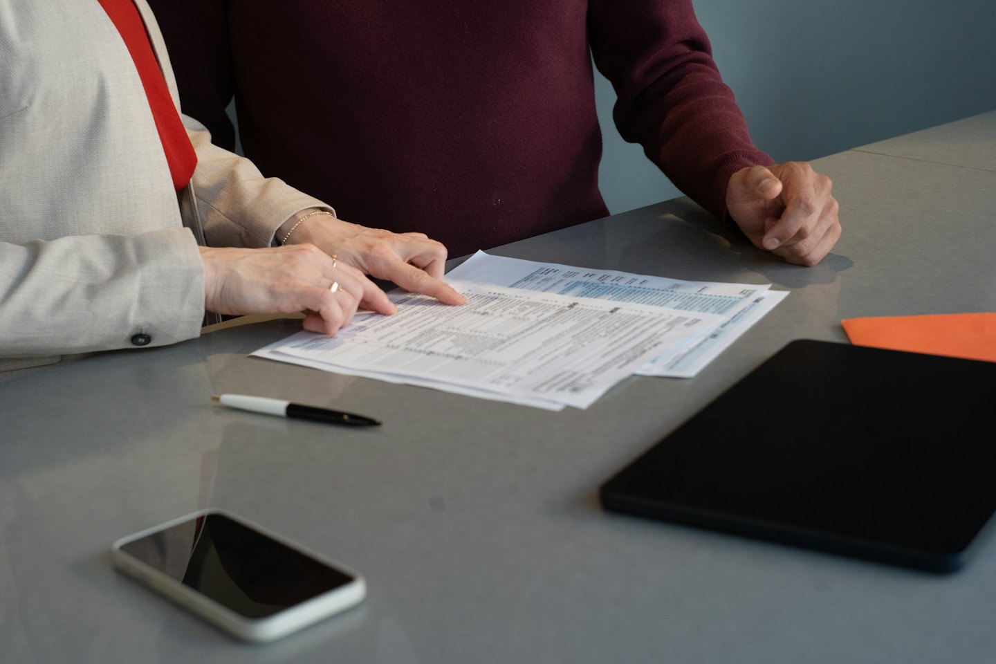 Deux personnes examinant des documents financiers à un bureau.